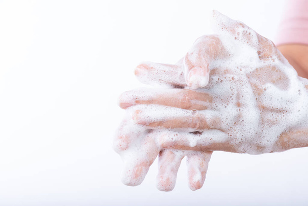 Lähikuva nainen pestä kädet saippualla valkoisella taustalla. Terveydenhuollon ja desinfioinnin käsite
. - Valokuva, kuva