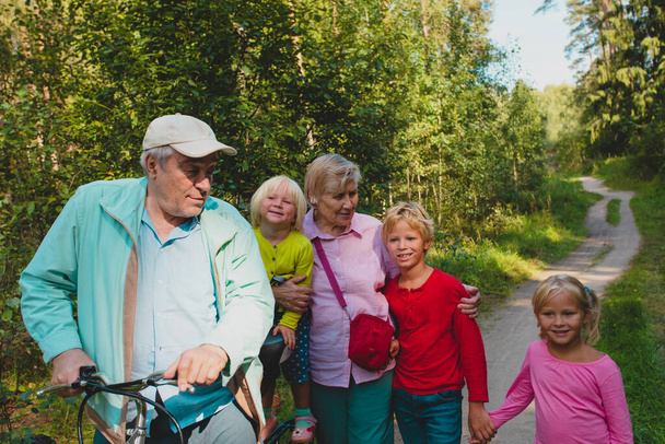 aktiivinen vanhempi isovanhemmat lasten kanssa ratsastus polkupyöriä luonnossa
 - Valokuva, kuva
