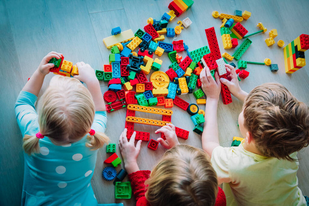 kinderen die met plastic blokken spelen, thuisblijven, leren en spelen - Foto, afbeelding