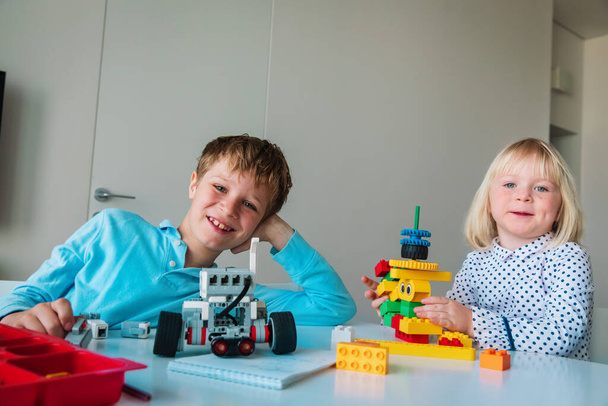 little girl and boy building robots from colorful plastic blocks - Photo, Image