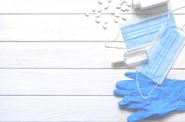 Ένα ζευγάρι λεπτά μπλε ιατρικά γάντια λάτεξ και ασπίδα προσώπου σε λευκό φόντο. Διαθέσιμα ελαστικά ιατρικά γάντια και μάσκα. Προστατευτικά υποκείμενα - Φωτογραφία, εικόνα