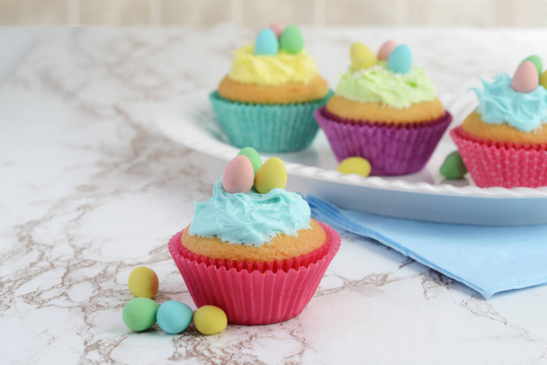 easter cupcakes on a platter with eggs - Фото, зображення