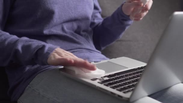 Woman rubs keyboard with antibacterial wipe. - Imágenes, Vídeo
