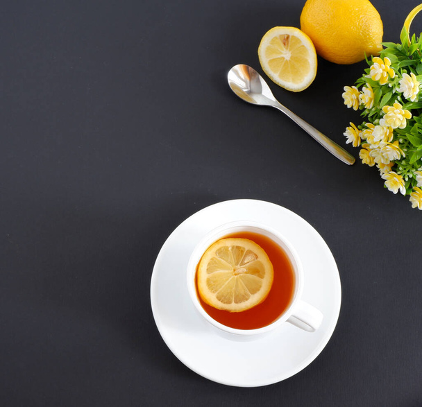 tea with lemon on a black background. Set: ceramic mug and saucer on a white background. Beautiful advertising background - Foto, imagen