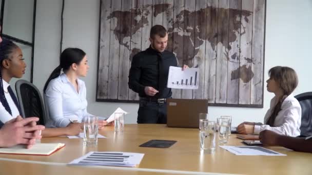 Business coach gives corporate presentation for businesspeople in office, dark skinned businessman presents new business plan, speaking to clients - Filmmaterial, Video