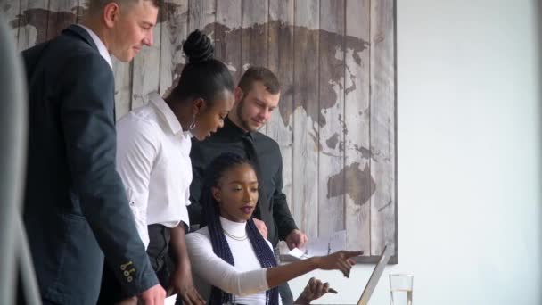 Красивая африканская американская бизнесвумен пользуется ноутбуком, консультирует своих многорасовых подчиненных
 - Кадры, видео