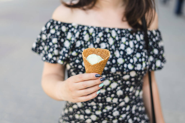 Joung woman holds vanilla ice cream in cone. - Photo, Image