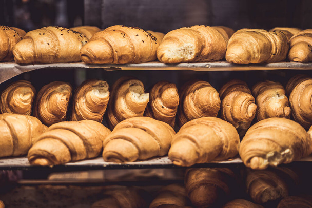 Croissants on a showcase in a bakery shop - Фото, зображення