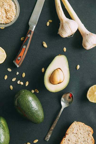 Avocado on a dark background with seeds. Natural vegetarian food. Ripe avocado cut with garlic Flatley.  - Fotó, kép