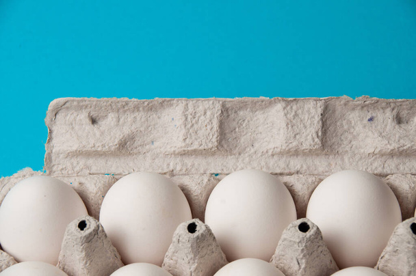 Eggs in a tray on blue background. Conceptual photo with place for text. - Photo, Image