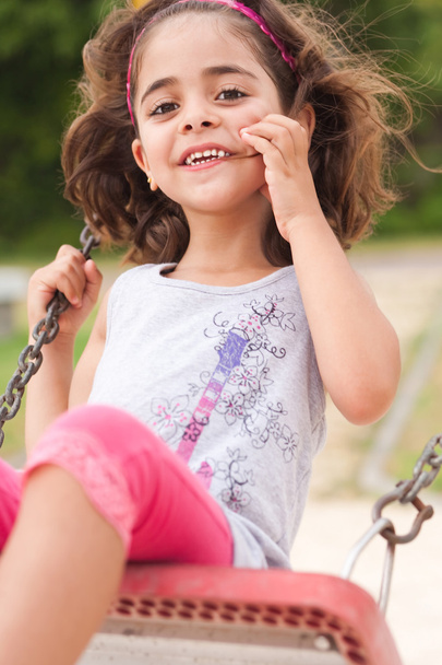 Lovely girl on a swing in the park - Фото, зображення