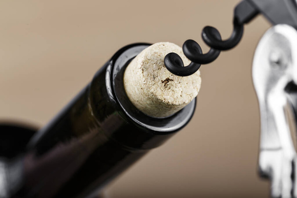 botella de vino con un sacacorchos en un corcho, primer plano. inicio de una celebración o velada romántica
 - Foto, Imagen