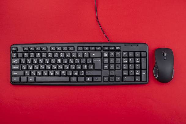 Computer mouse and keyboard on a reddish background. Top view. Computer peripherals. - Photo, image