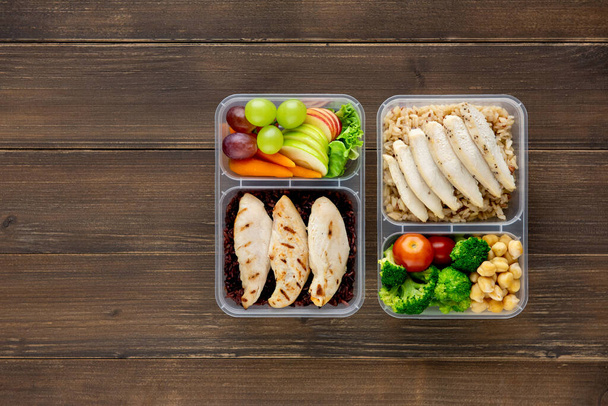 Aliments sains riches en nutriments et faibles en gras dans les coffrets repas à emporter sur fond bois vue du dessus avec espace de copie
 - Photo, image