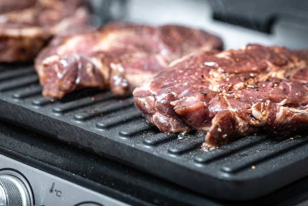 Świeże marmurkowe mięso na grillu elektrycznym gotowane  - Zdjęcie, obraz