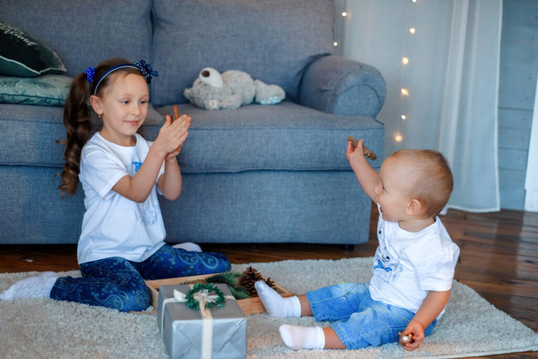 Cute little caucasian kids siblings laughing and playing at home show love and care, small girl sister embrace toddler brother, take care of cousin, family relationships, children support concept - Photo, Image