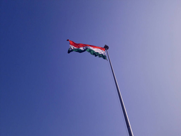 Niski kąt ujęcia flagi indyjskiej na niebieskim tle. - Zdjęcie, obraz