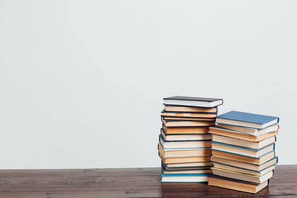 muitas pilhas de livros educacionais para ensinar em casa antes de exames em um fundo branco
 - Foto, Imagem