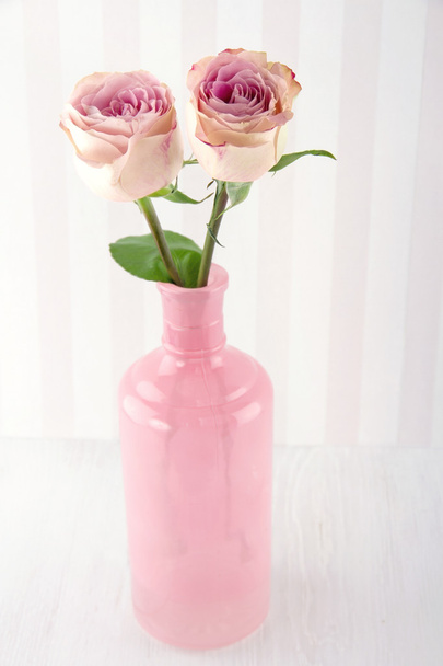 Duas rosas cor-de-rosa numa garrafa de vidro
 - Foto, Imagem
