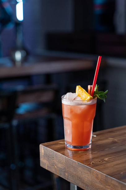 Zombie koktejl na bázi rumu a grapefruitové šťávy na dřevěném stole v moderním baru - Fotografie, Obrázek