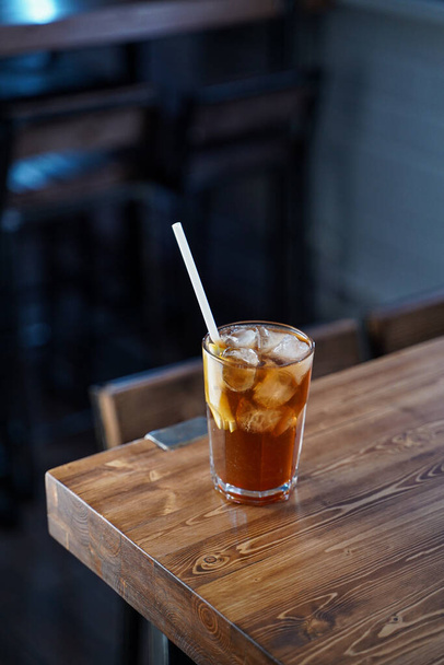Modern classics mixology: cuba libre with rum and cola on wooden bar counter, atmospheric shot - Fotografie, Obrázek