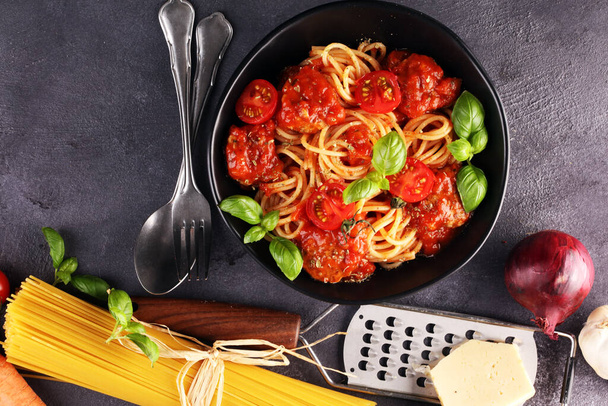 Tasty appetizing classic italian spaghetti pasta with tomato sauce, cheese parmesan and basil with ingredients - Foto, immagini