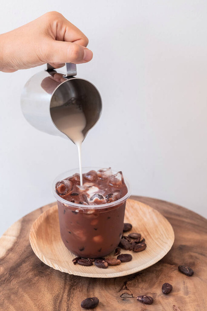 Ледяной шоколадный напиток с пеной и какао бобы изолированы на белом фоне
. - Фото, изображение