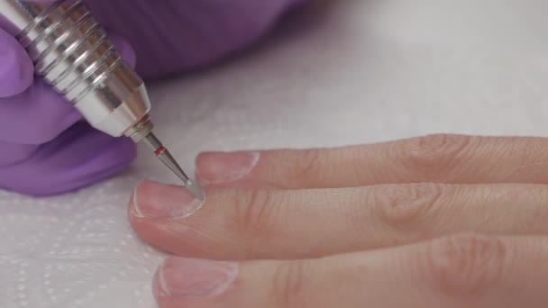 Jeune femme enlève gel gomme laque des ongles à l'aide de la machine de manucure, gros plan
 - Séquence, vidéo