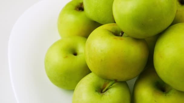 The mound of apples.Green fruit on a white plate.Whole,fresh fruit. - Felvétel, videó