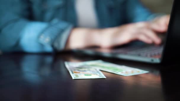 Entrepreneur working online on laptop and receiving income in dollar bills - Video, Çekim