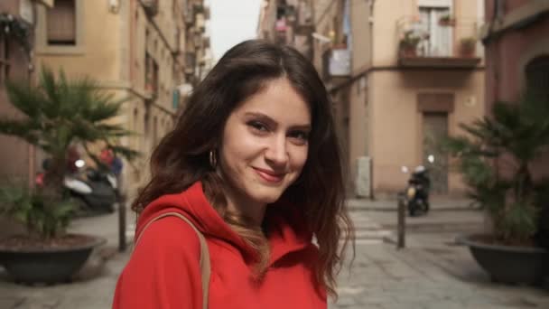 Traceren van shot van aantrekkelijke brunette hispanic meisje gelukkig op zoek in camera op gezellige stad straat - Video