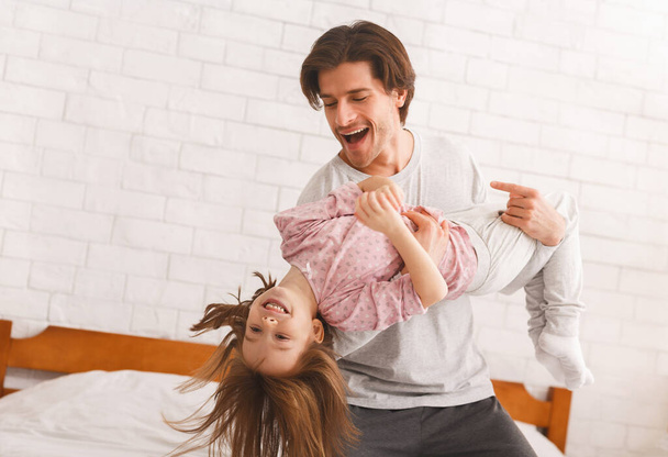 Молодой отец играет со своей дочкой дома
 - Фото, изображение