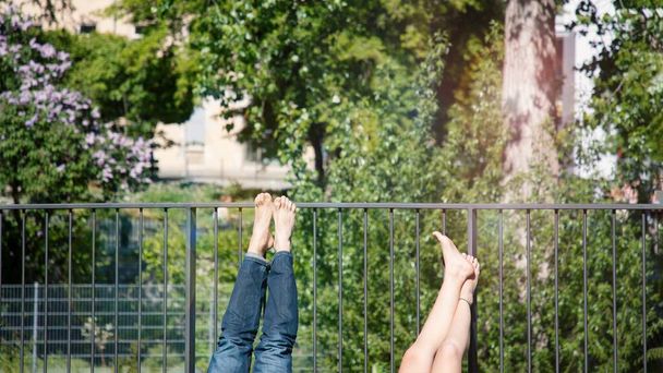 Legs barefoot sunbathing on the balcony. 16 on 9 panoramic format. Sunny day - Photo, Image