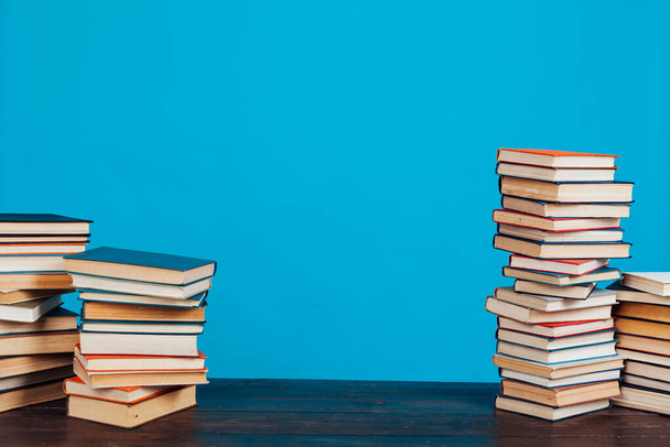 muchos de los libros educativos para la preparación de aprendizaje para los exámenes universitarios en un fondo azul
 - Foto, imagen