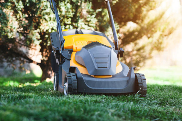Electric lawn mower on a lawn at the garden - Photo, Image