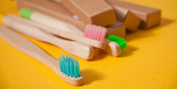 Eco bamboo kid colorful toothbrushes on the yellow background. - Foto, afbeelding