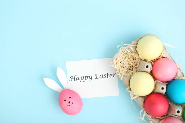 Huevos de Pascua con caras y orejas lindas sobre un fondo de color
. - Foto, imagen