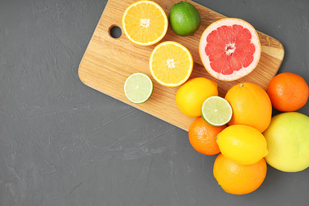 Different citrus and juicy slices on a colored background top view. Place to insert text. - Φωτογραφία, εικόνα