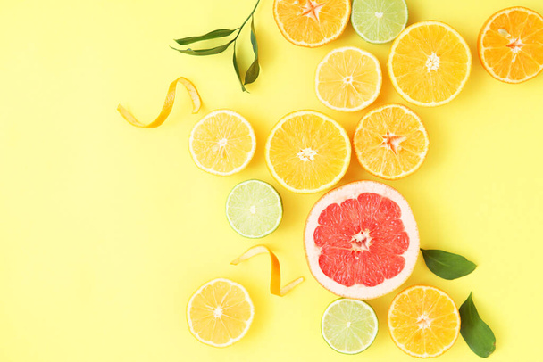 Different citrus and juicy slices on a colored background top view. Place to insert text. - Photo, Image