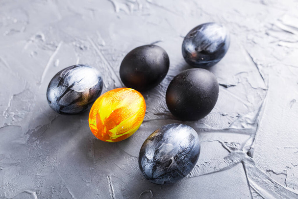 Holidays, design and modern easter concept - Black and brown easter eggs style minimalism on grey background. - Photo, Image