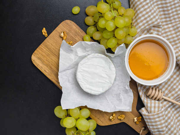 М'який сир і виноград на дереві з горіхами
 - Фото, зображення