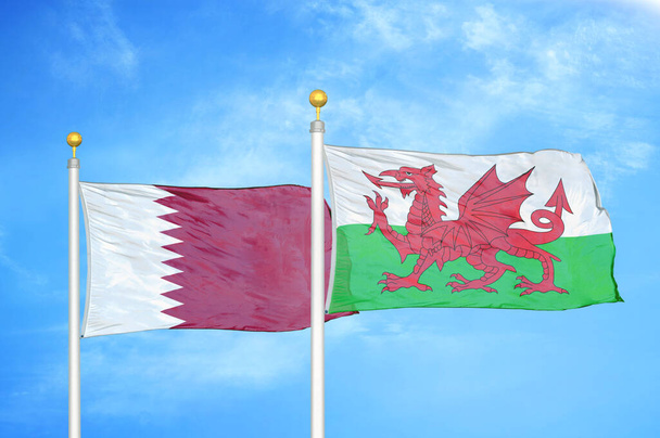 Katar a Wales dvě vlajky na vlajkových stožárech a modrá oblačná obloha pozadí - Fotografie, Obrázek
