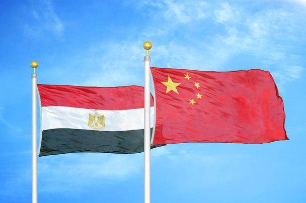Mısır ve Çin bayrak direkleri üzerinde iki bayrak ve mavi bulutlu arka plan - Fotoğraf, Görsel