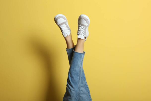 sneakers on female legs on a colored background. - Photo, Image