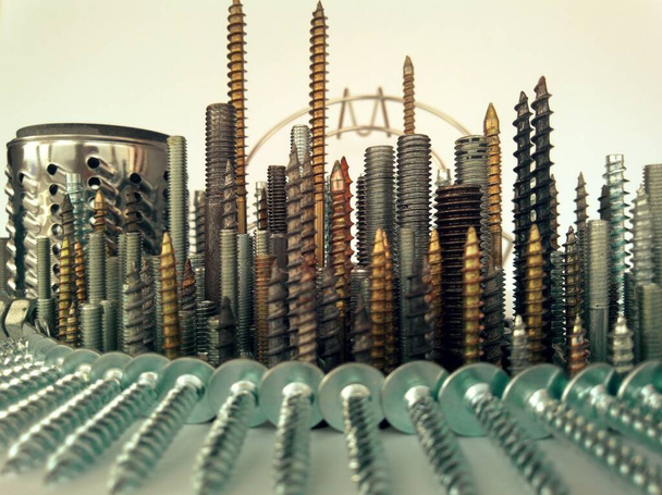 abstract metal city of bolts and screws in a creative macro photo - 写真・画像