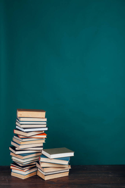 muitos dos livros educacionais para a preparação de aprendizagem para exames universitários em um fundo verde
 - Foto, Imagem