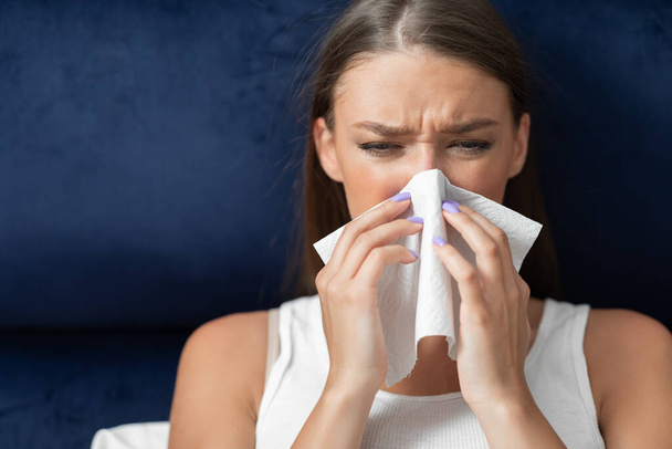 Malade femme soufflant nez dans le papier tissu assis dans le lit
 - Photo, image