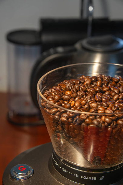 Moedor de café com botão de início vermelho, preenchido com grãos de café frescos
 - Foto, Imagem