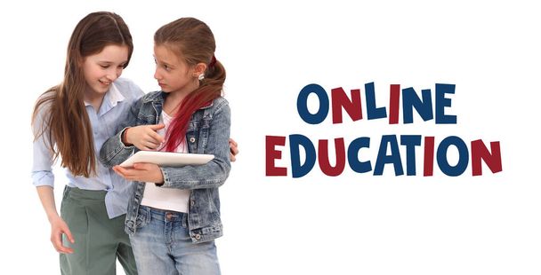 Online εκπαιδευτική ιδέα. Δύο κορίτσια δείχνουν μια νέα εφαρμογή σε μια ψηφιακή ταμπλέτα. Λευκό φόντο - Φωτογραφία, εικόνα