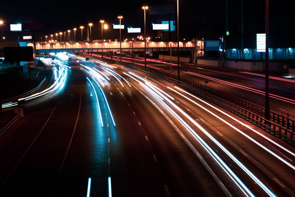 Tráfico en movimiento en una larga exposición en una carretera nocturna en la ciudad
. - Foto, Imagen